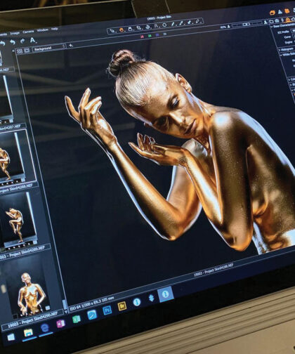 This shows a computer screen on which is a photo of a woman painted in gold, striking an artistic pose.