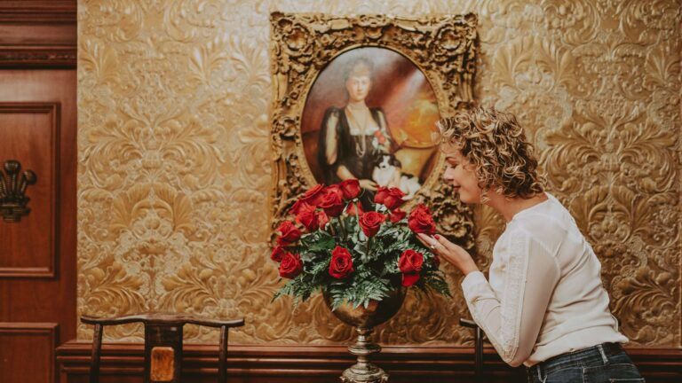 A woman admires some flowers.