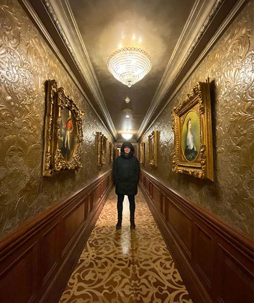 A man stands in a beautifully ornate hallway in one of the Vintage Hotels properties.