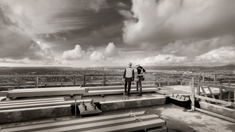 Two people gaze out at the city.