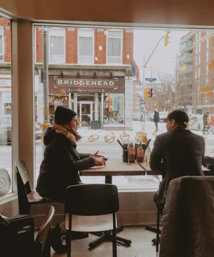 Two people sit a table in a restaurant.