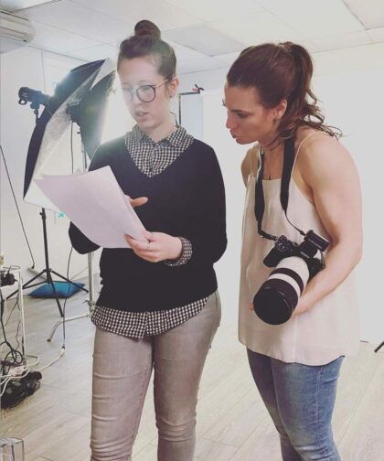 Two women reviewing a shot list in a photo studio