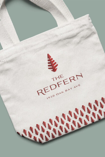 A tote bag featuring The Redfern name, logo, and building address.
