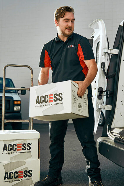 A man holds a box that says Access. Two other boxes are stacked nearby..