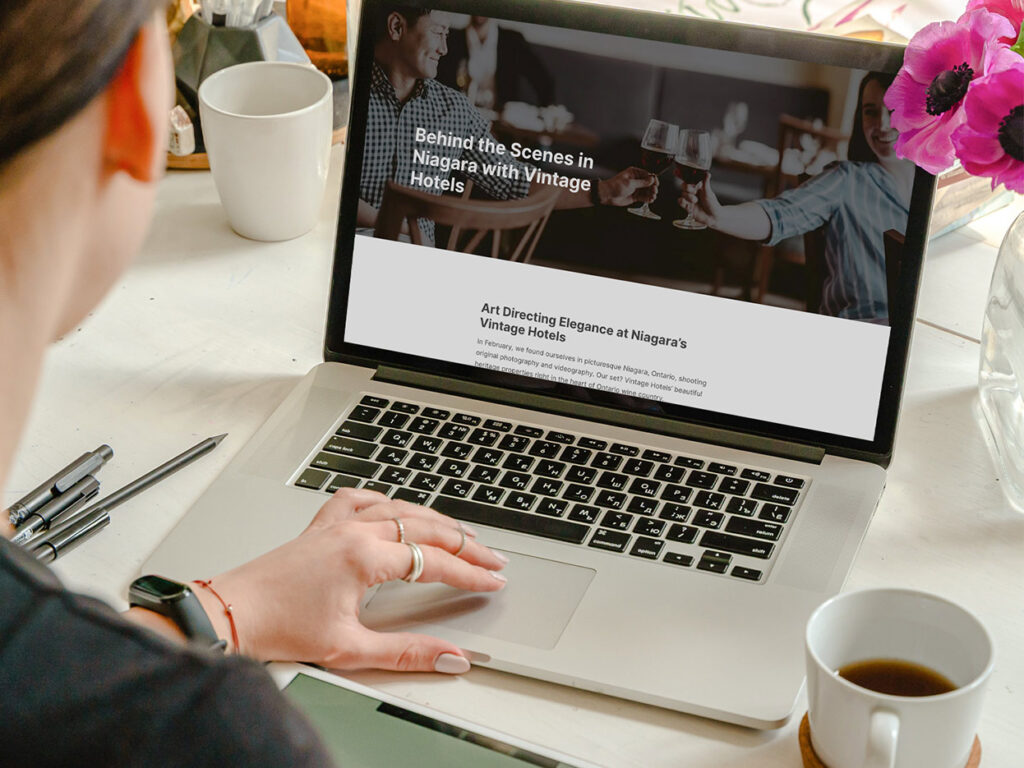 A person sits in front of a computer screen, reading the page of a website. 